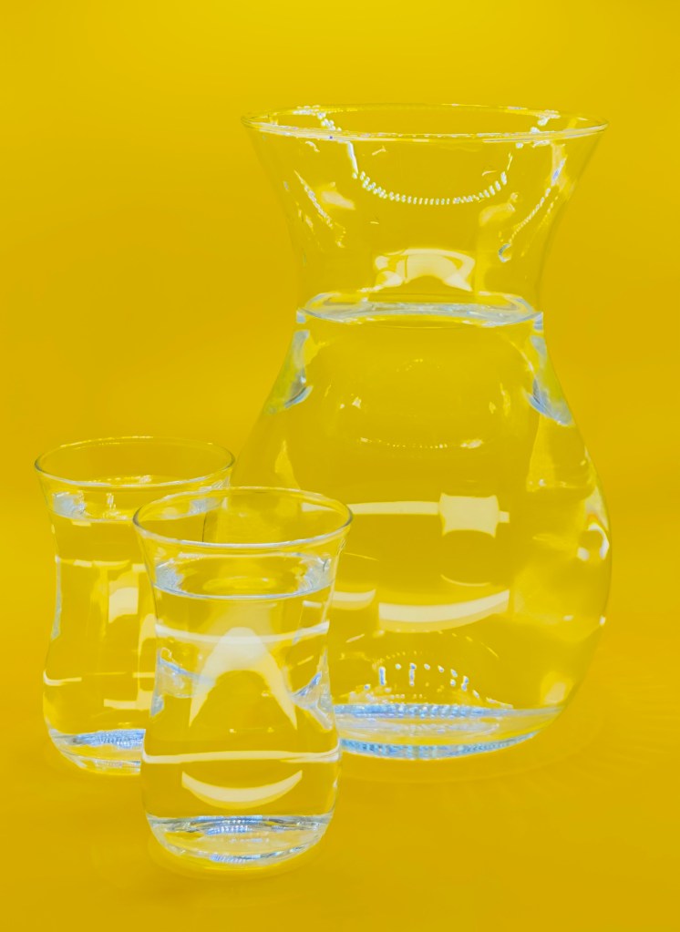 A glass jug glowing with energy, filled with water, symbolizing revitalization and health.